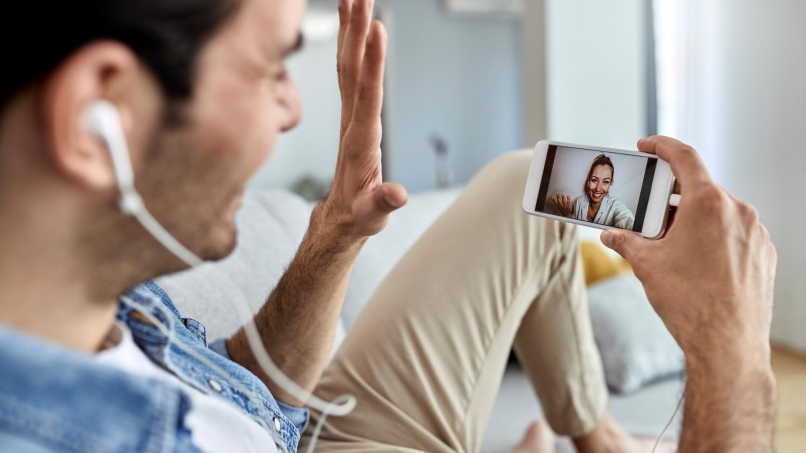 primer-plano-hombre-que-usa-telefono-movil-saluda-mientras-tiene-videollamada-su-novia